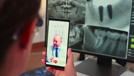 Close-up-of-assistant-having-videocall-with-specialist-stomatologist