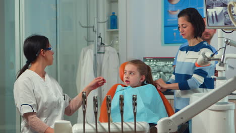 Pediatric-woman-dentist-treating-little-girl-patient-in-stomatological-office