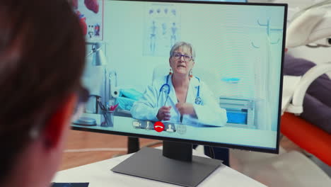 Rückansicht-Einer-Krankenschwester,-Die-Vor-Der-Webcam-Mit-Einem-Leitenden-Stomatologen-Diskutiert