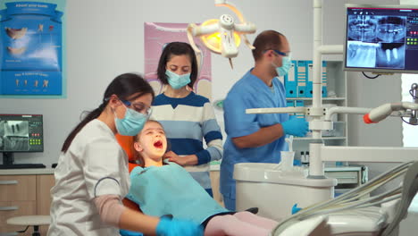 Zahnarzttechniker-Mit-Handschuhen-Erklärt-Dem-Kleinen-Patienten-Den-Vorgang
