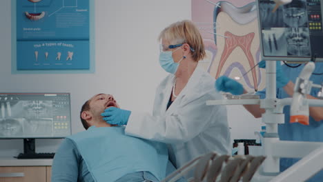 Zahnarzt-Mit-Gesichtsmaske,-Der-Zahnärztliche-Instrumente-Verwendet,-Um-Die-Prothese-Zu-Untersuchen