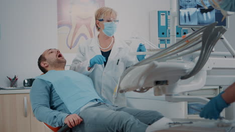Patient-Mit-Offenem-Mund-Wird-Vom-Zahnarzt-Untersucht