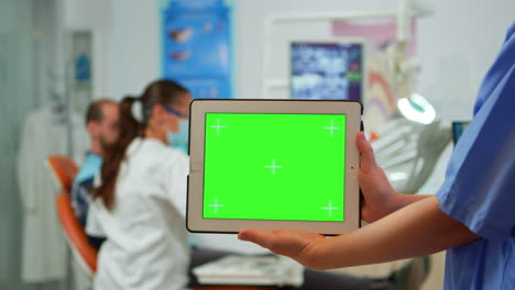 Zahnarztschwester-Hält-Tablet-Mit-Greenscreen-Display
