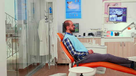 Ortodoncista-Discutiendo-La-Resonancia-Magnética-Con-El-Paciente-Antes-De-La-Cirugía