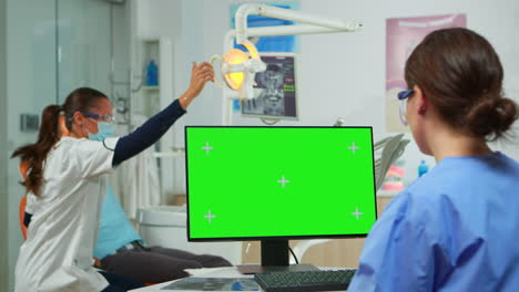 Krankenschwester-Schaut-Auf-Den-Grünen-Bildschirm,-Während-Der-Arzt-Den-Patienten-Untersucht