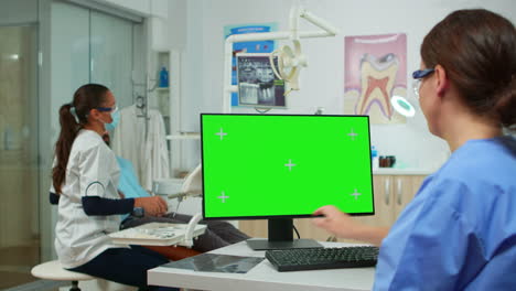 Stomatologe-Krankenschwester-Blickt-Auf-Ein-Green-Screen-Tablet