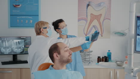 Dentista-Senior-Y-Enfermera-Analizando-Rayos-X-Para-Encontrar-Un-Diagnóstico