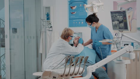 Dentista-Y-Enfermera-Examinando-Los-Dientes-Del-Paciente-En-El-Gabinete-De-Odontología
