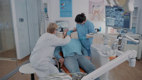 Dentista-Y-Asistente-Haciendo-Consulta-Con-Herramientas-Dentales