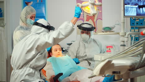 Técnico-Dentista-En-Overol-Perforando-Dientes-De-Niño-En-Clínica-Dental