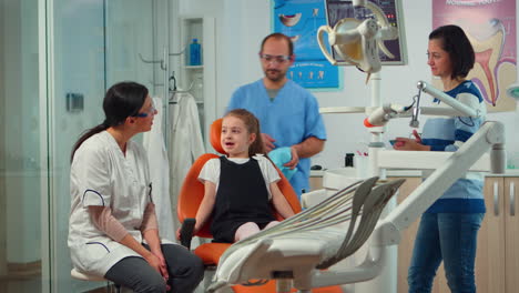 Little-girl-patient-with-tooth-pain-explaining-dental-problem-to-pediatric-dentist