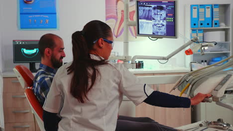 Técnico-Dentista-Con-Gafas-Explicando-La-Cirugía