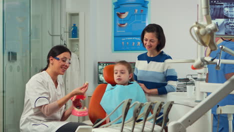 Stomatologist-explaining-to-kid-proper-dental-hygiene-using-teeth-skeleton