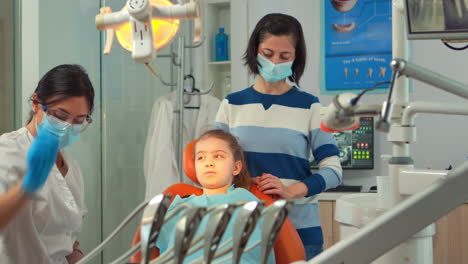Ortodoncista-Encendiendo-La-Lámpara-Hasta-Examinar-Al-Niño