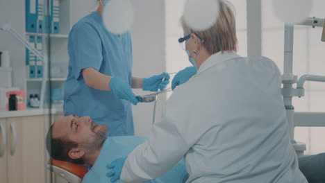 Team-Von-Spezialisten,-Die-Einen-Chirurgischen-Eingriff-An-Einem-Mann-Mit-Zahnschmerzen-Durchführen