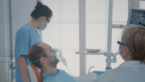 Trabajador-De-Cuidado-Bucal-Dando-Máscara-De-Oxígeno-Con-Anestesia-Al-Paciente