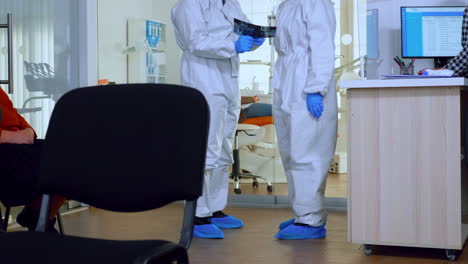 Orthodontics-doctors-with-face-shield-and-ppe-suit-discussing