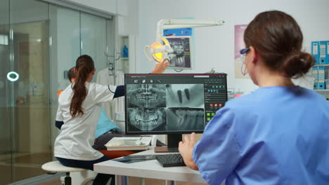 Enfermera-Analizando-Radiografías-Digitales-Sentada-Frente-A-La-PC