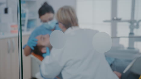 Dentist-and-nurse-using-dental-drill-machine-to-treat-caries