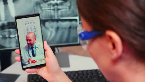 Close-up-of-nurse-talking-on-video-call-with-specialist-dentistry-doctor