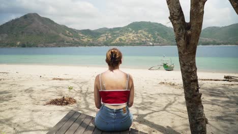 Mujer-Joven-Y-Atractiva-Sentada-En-Un-Muelle-De-Madera-En-Una-Playa-Tropical-En-Indonesia