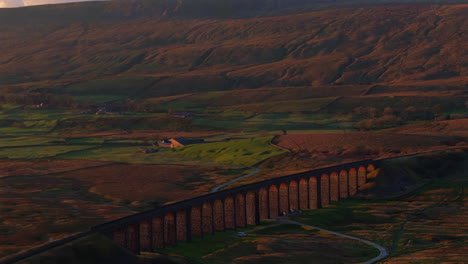 Establishing-Aerial-Drone-Shot-of-Ribblehead-Viaduct-at-Sunset-with-Whernside-Mountain-Behind-in-Yorkshire-Dales-UK