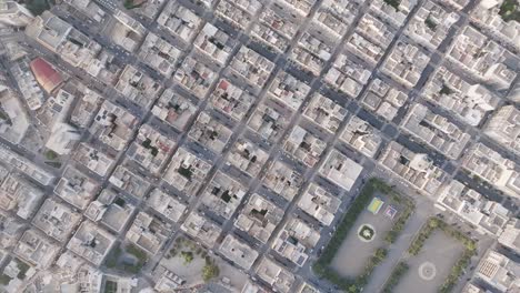 Top-down-aerial-footage-rotating-showing-the-buildings-of-downtown-Monopoli,-Italy-during-the-early-morning