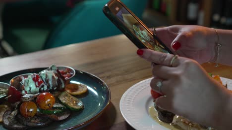 Hände-Einer-Frau,-Die-Mit-Ihrem-Smartphone-Appetitliches-Essen-Fotografiert