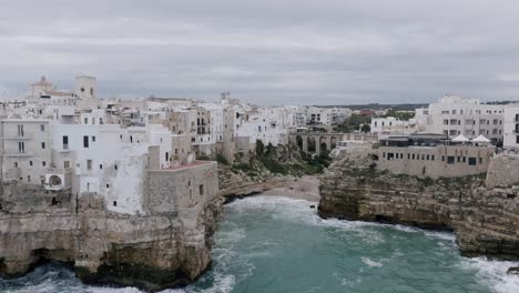 Aerial-footage-pulling-out-away-from-the-buildings-and-beach-of-Polignano-a-Mare-during-a-cloudy-day-in-Italy