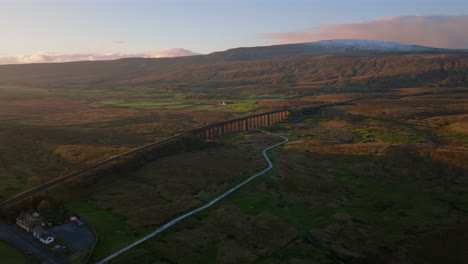 Hochkarätige-Drohnenaufnahme-Des-Ribblehead-Viadukts-Und-Der-Schneedecke-Von-Whernside-Bei-Sonnenuntergang-In-Yorkshire-Dales,-Großbritannien