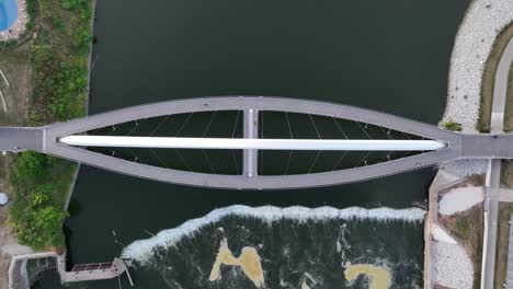 Top-down-aerial-shot-Iowa-Women-of-Achievement-Bridge-over-Des-Moines-River-with-white-water