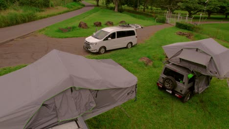 Drone-image-pulling-away,-unveiling-3-campervans-in-a-camping-site-in-Bijagual,-Costa-Rica
