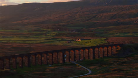Establishing-Aerial-Drone-Shot-Long-Lens-of-Ribblehead-Viaduct-and-Whernside-at-Golden-Hour-Sunset-in-Yorkshire-Dales-UK