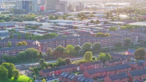 Apartment-buildings-and-street-traffic-in-Manchester,-rising-aerial