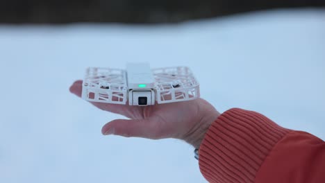 Close-up-of-Hoverair-X1-self-flying-drone-on-palm-of-hand-with-moving-camera