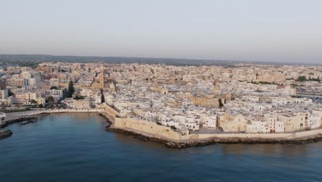 Aerial-footage-rotating-off-the-coast-of-Italy-around-the-town-of-Monopoli-in-the-light-of-the-sunrise