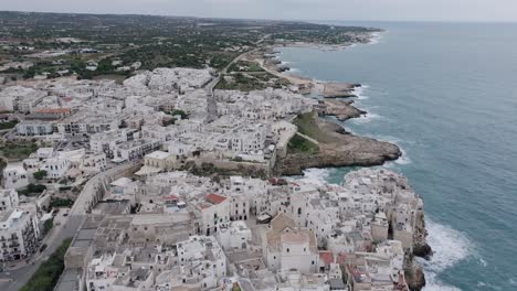 Wide-slow-aerial-footage-of-the-coastal-town-of-Polignano-a-Mare,-Italy