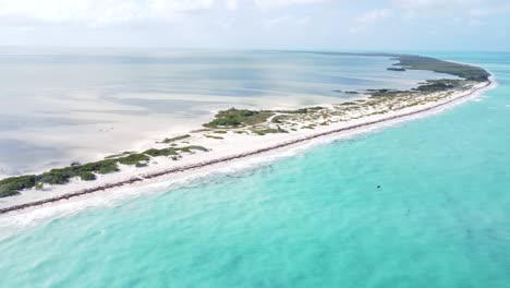 Panoramic-aerial-view-of-Isla-Blanca-beach-with-white-sands-and-blue-Caribbean-Sea-waves-in-Cancun,-Mexico