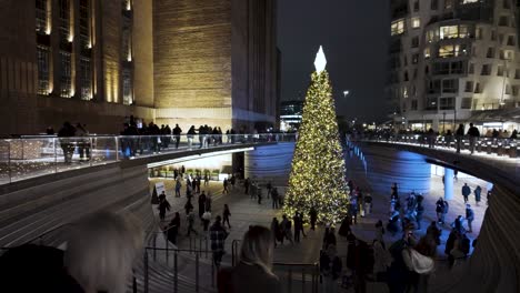 Mit-Blick-Auf-Geschäftige-Menschenmassen,-Die-Am-Beleuchteten,-Festlichen-Weihnachtsbaum-Am-Kraftwerk-Battersea-Vorbeilaufen