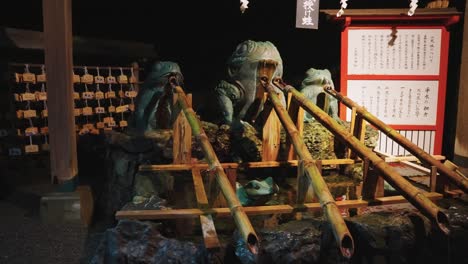 Futami-Shrine-at-Night,-Slow-Motion-Pan-over-Frog-Fountain