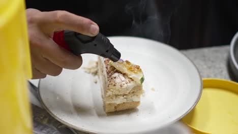 Chef-prepares-the-recipe-using-a-blowtorch-to-crystallize-the-sugar-in-a-dessert