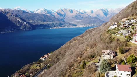 Hillside-mountain-homes-and-majestic-panoramic-view-of-Lake-Como,-aerial-view