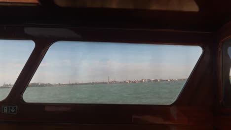 Venezia-city-in-horizon-seen-from-inside-of-captains-cabin-in-fast-moving-boat