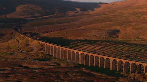 Establishing-Aerial-Drone-Shot-of-Ribblehead-Viaduct-at-Sunset-Golden-Hour-in-Yorkshire-Dales-UK