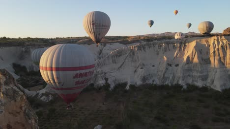 Drone-view-of-touristic-balloons-flying-in-the-valley,-a-very-famous-tourist-event-in-Turkey-Cappadocia