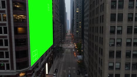 Urban-street-in-USA-city-with-a-green-screen-billboard-on-a-skyscraper