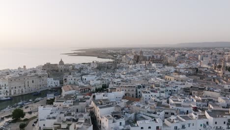 Aerial-flyover-in-the-morning-of-the-small-downtown-of-Monopoli,-Italy