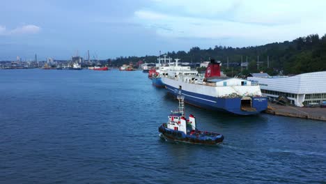 Tug-Boat-Passing-By-Passenger-Ship-Docked-At-The-Port-In-Balikpapan,-Indonesia