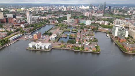 Salford-Quays-waterfront-district-with-Manchester-skyline-in-background,-aerial