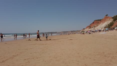 Menschen,-Die-Am-Strand-Spazieren-Gehen-Und-Spielen,-Falèsia,-Algarve,-Portugal